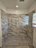 Luxurious shower with marble tiles in remodeled bathroom with Redi Trench barrier free shower pan by Tile Redi.